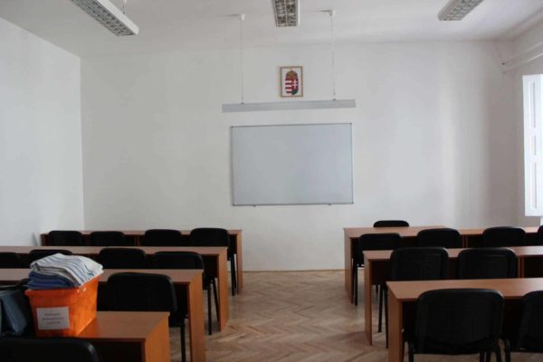 Pannon Kincstár parkettázott fehér színű fallal körülzárt terme. Fekete székek, padok, amik csak a tanulókra várnak. Terembérlés.