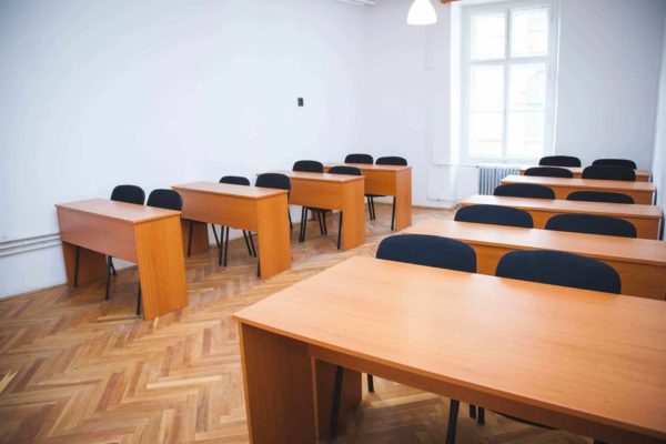 Oktatás a Pannon Kincstárban fekete színű székekkel és barna padokkal. Budapest Váci Utca 47, a belváros szívében, központjában. Terembérlés.