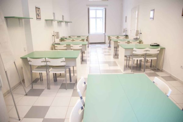 Pannon Kincstár iskola étkező. Fehér székek zöld színű asztalokkal. Terembérlés.