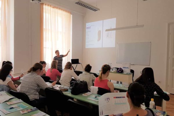 Oktatás a Pannon Kincstárban. Megújult, keresett képzések központja kellően felszerelve.Budapest Váci utca 47. Tanárnő és hallgatók az iskola egyik termében. Terembérlés.